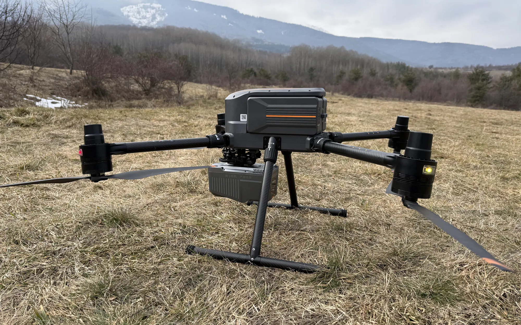 Дрон с LiDAR система CHCNAV AlphaAir на терен преди полет, с планина на заден план