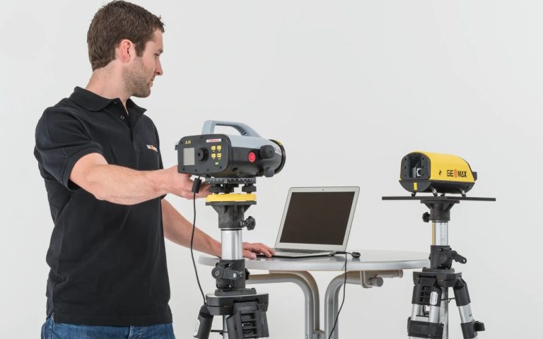 Техник настройва GeoMax CalMaster с лаптоп и уред на статив при калибровка